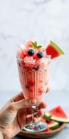 Refreshing watermelon and blueberry slush served in a tall glass with fresh mint garnish photo