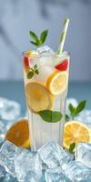 Refreshing lemonade with mint and strawberries served over ice in a tall glass during bright daylight photo