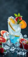 Refreshing blue drink garnished with citrus and berries served on ice with fresh fruit around photo