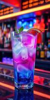Colorful cocktail with ice served at a vibrant bar during the night photo
