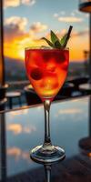 Bright cocktail with cherries and mint against a sunset backdrop in a lively bar setting photo