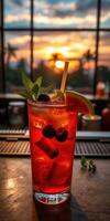 Colorful cocktail garnished with mint and fruit at sunset in a tropical setting photo