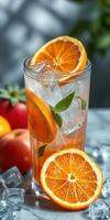 Refreshing citrus drink with ice garnished with mint leaves and surrounded by apples photo