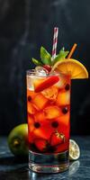 Colorful refreshing cocktail with fruits and mint served on a dark surface photo