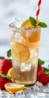 Refreshing iced tea with lemon and strawberries in a tall glass garnished with mint leaves photo