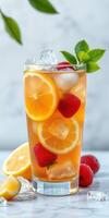 Refreshing summer drink featuring iced tea with citrus slices and fresh berries in a tall glass photo