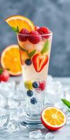 Refreshing fruit cocktail with ice served in a tall glass at a summer gathering in a lively outdoor setting photo