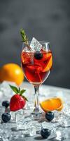 Refreshing summer cocktail with ice, berries, and citrus fruits garnished elegantly in a clear glass photo