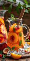 Refreshing fruit punch pitcher with juicy peaches and mint on a wooden table photo