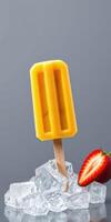Delicious mango popsicle positioned on ice alongside fresh strawberry photo