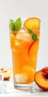 Refreshing peach iced tea with mint garnishment served in a tall glass during summer gathering photo