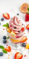 Delicious dessert featuring layered fruits and creamy swirl garnished with strawberries and blueberries photo