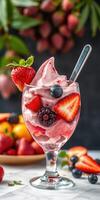 Freshly made berry swirl dessert topped with vibrant fruit in a glass on a marble surface photo