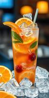 Refreshing citrus drink with ice and garnishes served in a tall glass at a vibrant bar setting photo