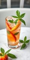 Refreshing cocktail with fresh peaches and mint served on a marble table photo