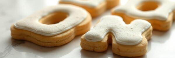 Decoratively frosted cookies shaped like letters displayed on a marble countertop in a well-lit kitchen photo