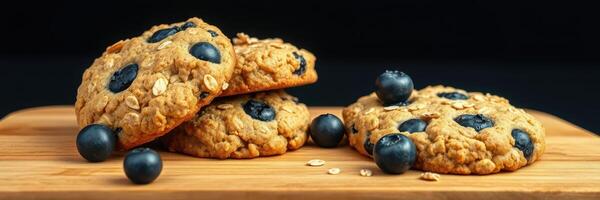 Freshly baked blueberry cookies arranged on a wooden board with fresh blueberries scattered photo