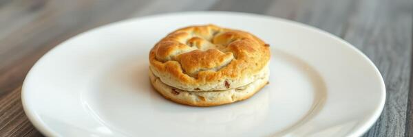 Delicious biscuit sandwich served on white plate in a cozy cafe setting during the afternoon photo