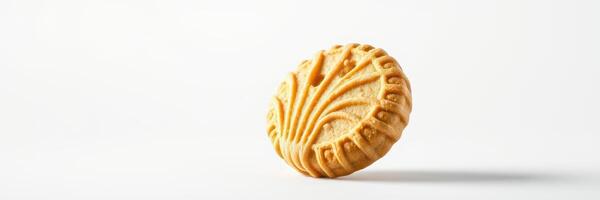 Delicate round cookie resting on a white surface, showcasing intricate design patterns and a golden color photo