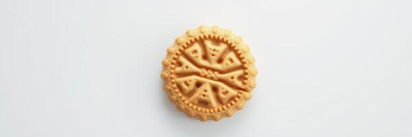 Round biscuit with intricate designs placed on a white surface showcasing the texture and detail of the cookie photo