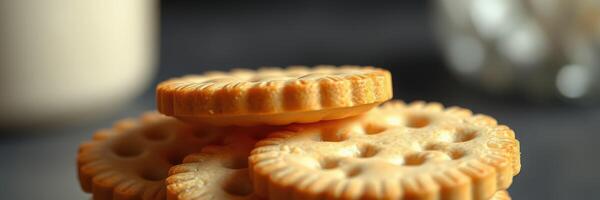 Delicious round cookies stacked on a dark surface with milk in the background during the afternoon photo