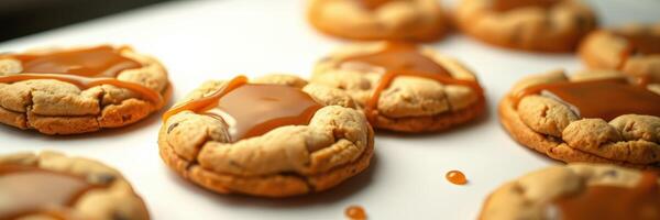 Delicious cookies with caramel drizzle cooling on a baking tray in a cozy kitchen setting photo