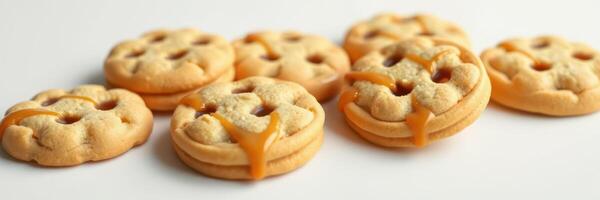 Delicious golden cookies filled with sweet caramel on a white surface photo