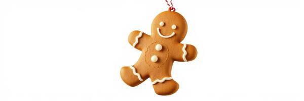 Gingerbread man ornament hanging on a festive tree branch during the holiday season photo