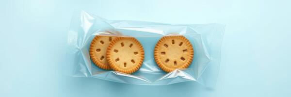 Delicious round cookies packed in a clear wrapper on a light blue background for a tempting snack experience photo