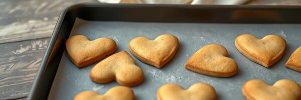 Freshly baked heart-shaped cookies cooling on a tray in a cozy kitchen photo