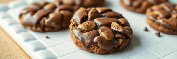 Soft chocolate cookies with chunks of chocolate displayed on a cooling rack in a cozy kitchen setting photo