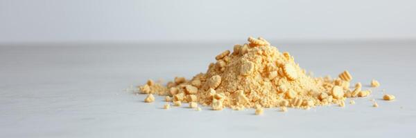 Ground yellow spice is heaped on a neutral background highlighting its texture and color during culinary preparation photo
