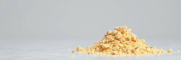 Yellow powder in a mound on a bright background with soft lighting showcasing texture and color photo