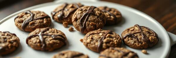 Homemade chocolate drizzled oatmeal cookies on a white plate ready for dessert photo
