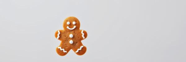 Gingerbread cookie with smiling face and decorative icing on a plain background photo