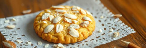 Crispy almond cookie resting on a lace-patterned napkin on a wooden table photo
