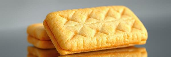 Enjoyment of golden-brown biscuits with unique patterns on a reflective surface captured in a close-up setting photo