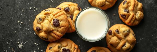 Warm cookies paired with a glass of milk on a dark surface for a comforting treat photo