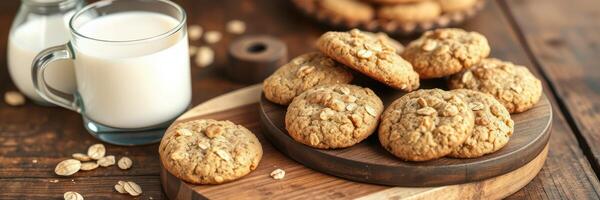 Freshly baked oatmeal cookies served with a glass of milk on a wooden table photo