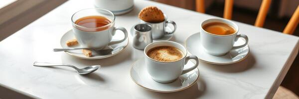 Coffee cups with pastries arranged on a white table in a cozy cafe during afternoon photo