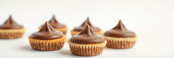 Chocolate topped mini cupcakes arranged on a light background for a sweet treat display photo