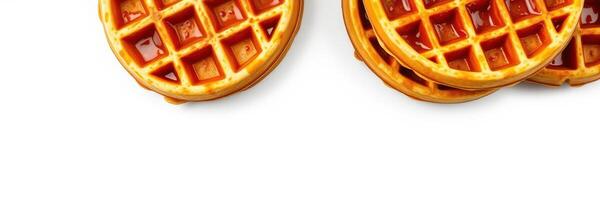 Deliciously golden waffles topped with syrup arranged on a white background ready for breakfast enjoyment photo