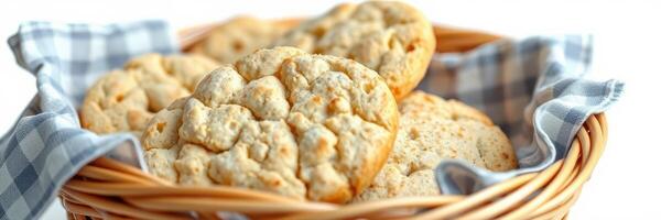 Freshly baked cookies in a woven basket with a checkered cloth on a white background photo