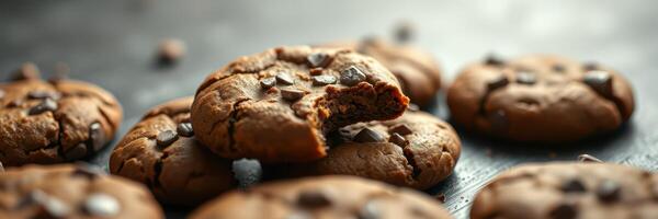 Freshly baked chocolate chip cookies with a bite taken out, served on a rustic wooden table in a cozy kitchen photo