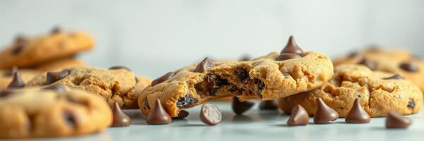 Freshly baked chocolate chip cookies with melting chocolate chips and a broken cookie on a light surface photo