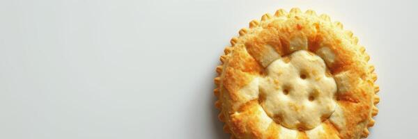 Freshly baked pie resting on a clean surface showcases golden crust and intricate design near a bright window photo