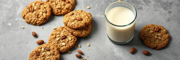 Delicious homemade oatmeal cookies with a glass of milk served on a stone countertop photo