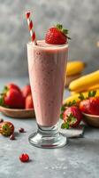 Refreshing strawberry banana smoothie served in a tall glass with a striped straw and fresh fruit on the table photo
