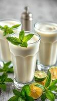 Refreshing mint yogurt drinks served with lime slices and mint leaves in a cozy setting photo