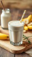Creamy banana smoothie served with fresh bananas and yogurt on a wooden table photo